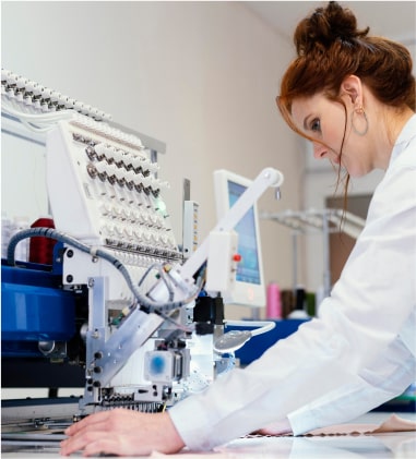 Female scientist in lab coat operating equipment in laboratory.